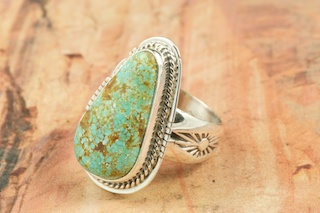 Genuine Number 8 Turquoise set in Sterling Silver Ring. The Number 8 mine is located in Eureka County Nevada. Since 1976 there has been no Number 8 Turquoise mined. There is however, an existing stock pile that Mr. Dowell Ward, the last owner of the Number 8 mine, had stocked away for later sorting. The Turquoise is a collector's item--because once the reserve is gone there will be no more material released onto the market. The Gold Mining Company owns the claim to the Number 8 mine and it has been swallowed up by the gold mining operations. This is some of the last Number 8 Turquoise to be had and will be a great addition to your collection. Created by Navajo Artist Lucy Valencia. Signed L. J. by the artist.